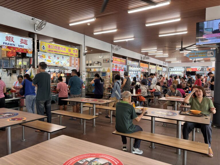 How Hawker Centres Work in Singapore: A First-Timer's Guide Busy hawker centre in Singapore with multiple food stalls and diners
