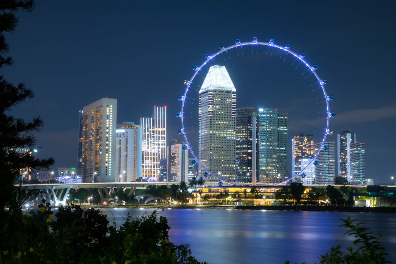 Crafting Captivating Headlines: Your awesome post title goes here Illuminated Singapore skyline and Ferris wheel reflecting over the water at night.
