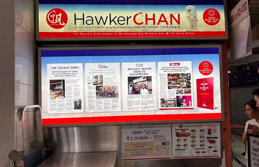 HawkerChan stall front displaying newspaper and magazine clippings about its Michelin star