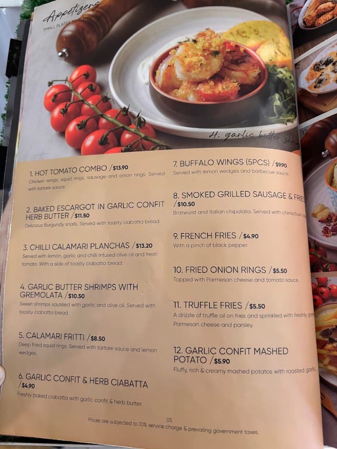 The bottom of a Singapore restaurant menu showing fine print that prices are subject to a 10% service charge and prevailing government taxes (GST).