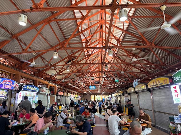Tourists and locals dining at tables inside the Maxwell Food Centre hawker market in Singapore