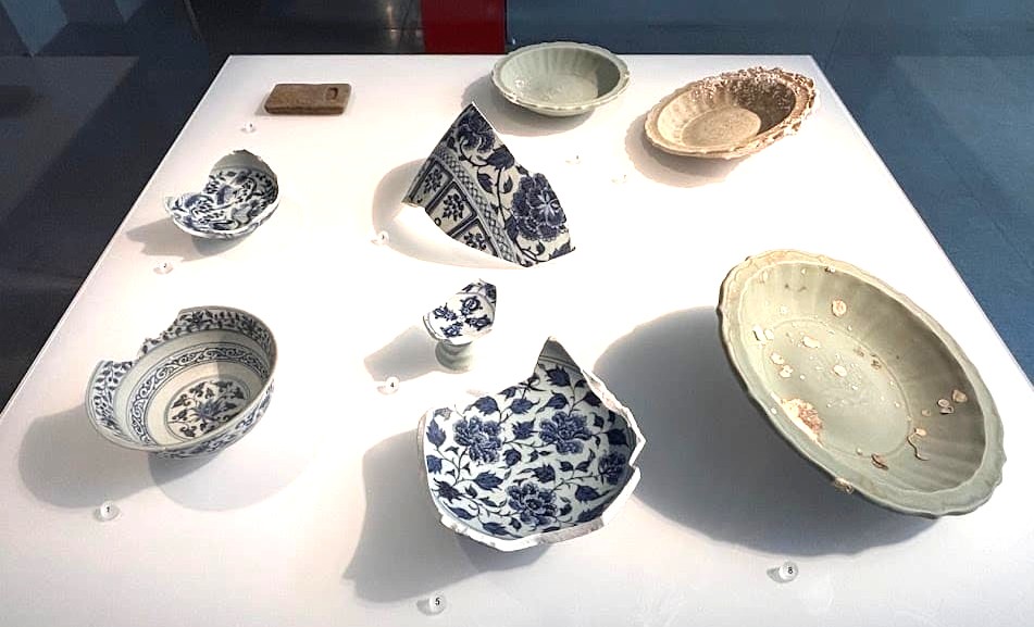 A display of broken and damaged Chinese ceramic fragments including blue-and-white bowls and celadon dishes recovered from Southeast Asian shipwrecks, at the Asian Civilisations Museum Singapore