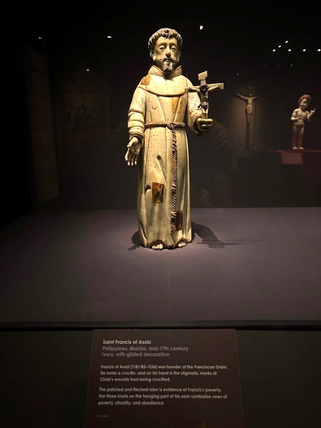 A 17th-century ivory and gilded statue of Saint Francis of Assisi from Manila, Philippines, holding a crucifix with stigmata marks on his hands, on display at the Asian Civilisations Museum Singapore