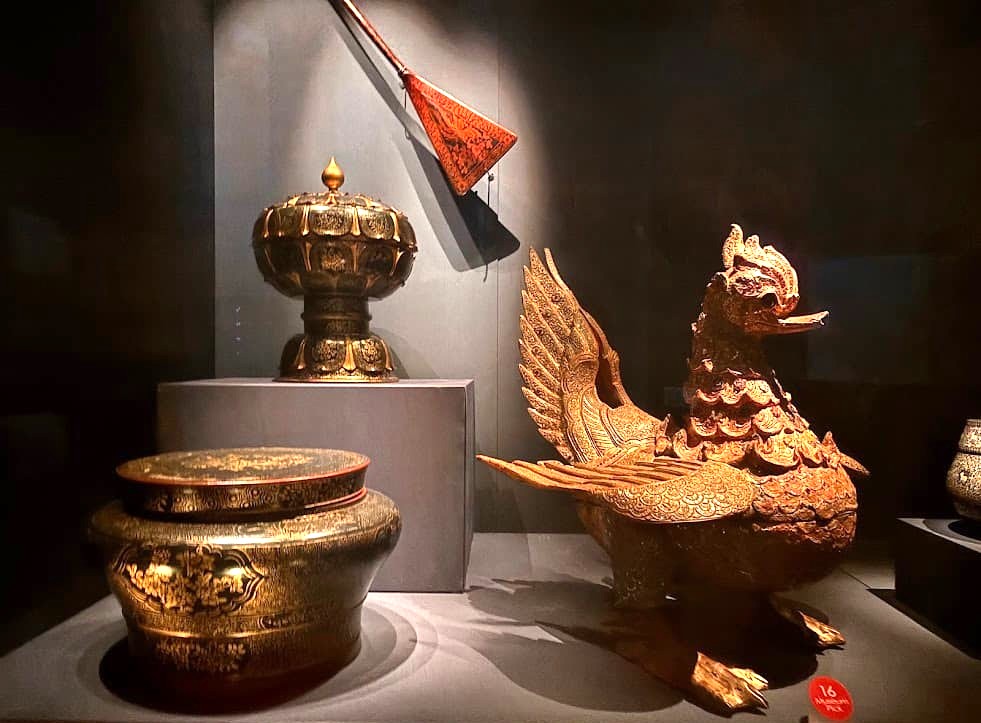 A lacquered and gilded wooden offering vessel in the form of a hintha bird on display at the Asian Civilisations Museum Singapore, decorated with inlaid glass and mirrors